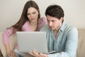 Young couple using laptop computer, having problems, anxious and Royalty Free Stock Photo