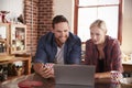 Young couple using a laptop in kitchen, close up, front view Royalty Free Stock Photo