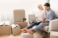 Young Couple Using Laptop Looking Through House Ownership Papers Indoor