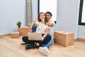 Young couple using laptop at new home approving doing positive gesture with hand, thumbs up smiling and happy for success Royalty Free Stock Photo