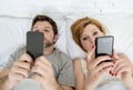 young couple using mobile phone in bed ignoring each other in relationship communication problems Royalty Free Stock Photo