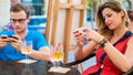 Young couple using mobile phones in a cafe.