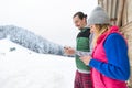 Young Couple Using Smart Phone Snowy Village Wooden Country House Man And Woman Online Messaging Winter Snow Royalty Free Stock Photo