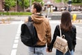 Young couple waiting to cross street, back view. Traffic rules and regulations Royalty Free Stock Photo