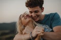 Young couple on a walk in nature at sunset in countryside, hugging and having fun. Royalty Free Stock Photo