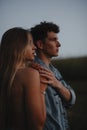 Young couple on a walk in nature at sunset in countryside, standing. Royalty Free Stock Photo