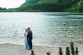 Young couple on a walk near the lake surrounded by the mountains