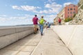 A young couple walk their dog along path at the Bay of Angels, on the French Riviera in Nice, France. Royalty Free Stock Photo