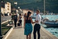 Young couple walking along the coastal lane in sunset.Man turning to see another woman,seeing ex girlfriend.Turning on and looking Royalty Free Stock Photo