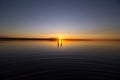 Young couple is walking away in the water on summer beach. Sunset over the sea.Two silhouettes against the sun. Just married Royalty Free Stock Photo