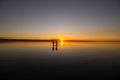 Young couple is walking away in the water on summer beach. Sunset over the sea.Two silhouettes against the sun. Just married Royalty Free Stock Photo