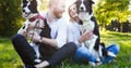 A young couple walking a dog in the park