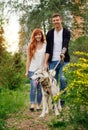 A young couple walking a dog in the park Royalty Free Stock Photo