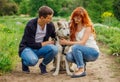 A young couple walking a dog in the park Royalty Free Stock Photo