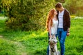 A young couple walking a dog in the park Royalty Free Stock Photo