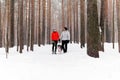 Young couple walking a dog in the winter forest Royalty Free Stock Photo