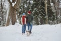 Young couple walking dog in winter forest and looking at each other Royalty Free Stock Photo