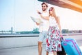 Young couple walking in front of an airport terminal building, pulling suitcases Royalty Free Stock Photo