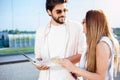 Young couple walking in front of an airport terminal building, pulling suitcases Royalty Free Stock Photo