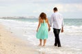 Young couple walking hand in hand on the beach thi Royalty Free Stock Photo