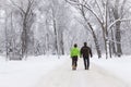 Young couple walking hand in hand on a snowy path in the winter time Royalty Free Stock Photo