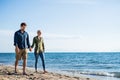 Young couple walking outdoors on beach, holding hands. Copy space. Royalty Free Stock Photo