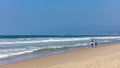 Young couple walking on the sandy beach. Blue ocean sea waves, clear blue sky in a sunny spring day Royalty Free Stock Photo