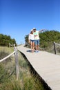 Young couple walking by the shore on wooden pontoon Royalty Free Stock Photo