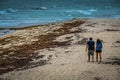 Young Couple Walking in the Wind on the Beach Royalty Free Stock Photo