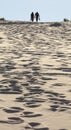 Young couple walks on sand dune. Fingal Bay. Port Stephens. Australia.