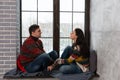 Young couple in warm knitted sweaters talking while sitting on t Royalty Free Stock Photo