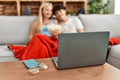 Young couple watching film and eating popcorn sitting on the sofa at home Royalty Free Stock Photo