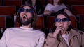 Young couple watching horror movie in 3D glasses. Media. Man and woman looking frightened and shocked while watching Royalty Free Stock Photo