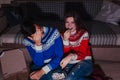 Young couple watching movie eating popcorn at home at night Royalty Free Stock Photo