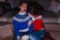 Young couple watching movie eating popcorn at home at night Royalty Free Stock Photo