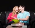 Young couple watching a movie while sitting on a sofa Royalty Free Stock Photo