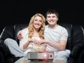 Young couple watching a movie while sitting on a sofa Royalty Free Stock Photo