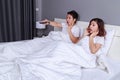 Couple watching scared movie with tv remote control on bed