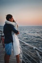 Young couple watching the sunrise at the beach, hugging together, seashore summer beach at yellow blue morning horizon sea Royalty Free Stock Photo