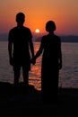 Young couple watching sunset on the beach Royalty Free Stock Photo