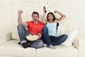 Young couple watching tv sport football game excited celebrating