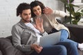 young couple waving hands and using laptop