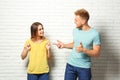 Young couple wearing blank t-shirts near white brick wall. Mockup for Royalty Free Stock Photo