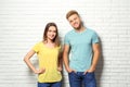 Young couple wearing blank t- near white brick wall. Mockup for design Royalty Free Stock Photo