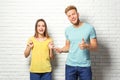 Young couple wearing blank t-shirts near white brick wall Royalty Free Stock Photo