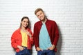 Young couple wearing blank t- near white brick wall. Mockup for design Royalty Free Stock Photo