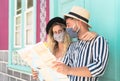 Young couple wearing face mask and holding travel map - Travelers people enjoying first trip after corona virus outbreak