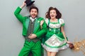 Young couple in festive costumes saint patrick`s day top view looking camera surprised