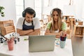 Young couple of wife and husband at art studio looking at video on laptop skeptic and nervous, disapproving expression on face Royalty Free Stock Photo