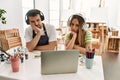 Young couple of wife and husband at art studio looking at video on laptop thinking looking tired and bored with depression Royalty Free Stock Photo